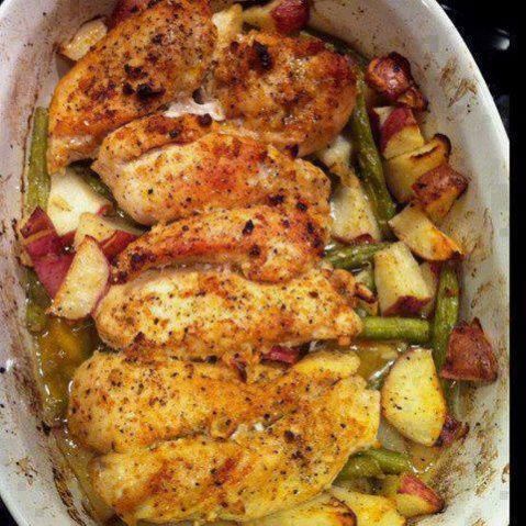 chicken, potatoes and green beans in a white casserole dish with seasoning