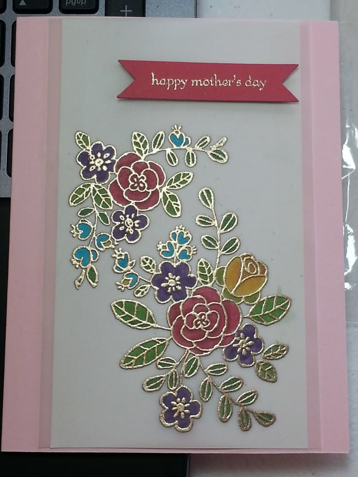 a card with flowers on it sitting next to a keyboard