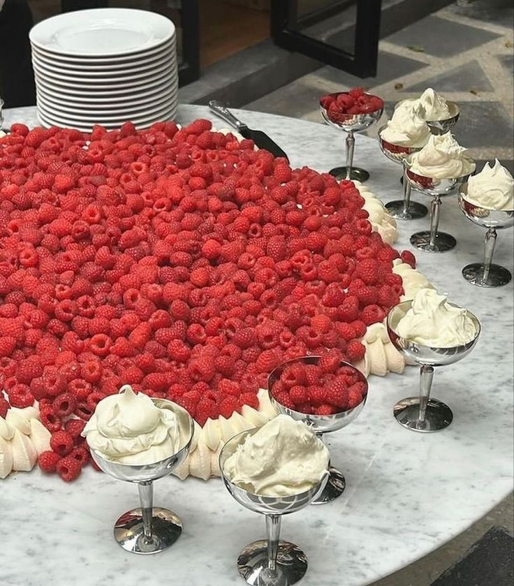 a large cake with white frosting and raspberries on it