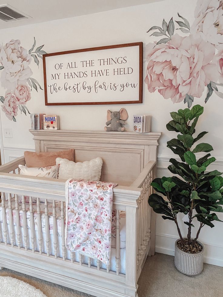 a baby's room with flowers on the wall and a crib in the foreground