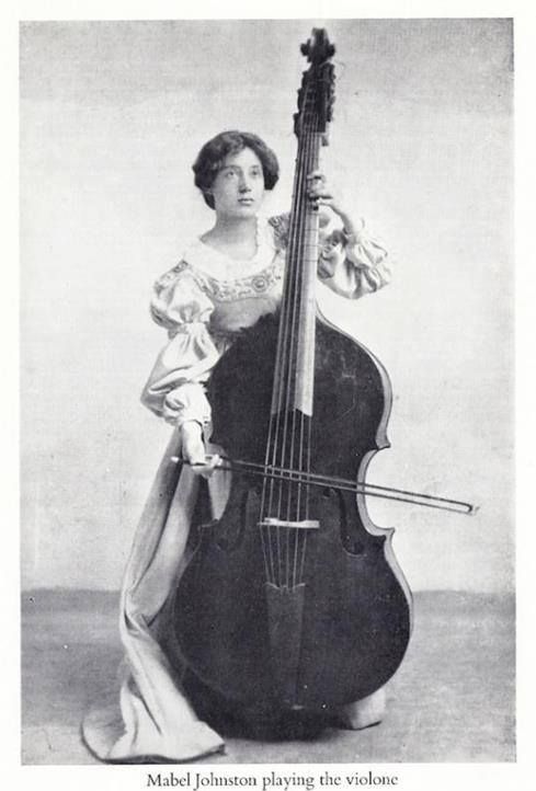 an old photo of a woman holding a cello