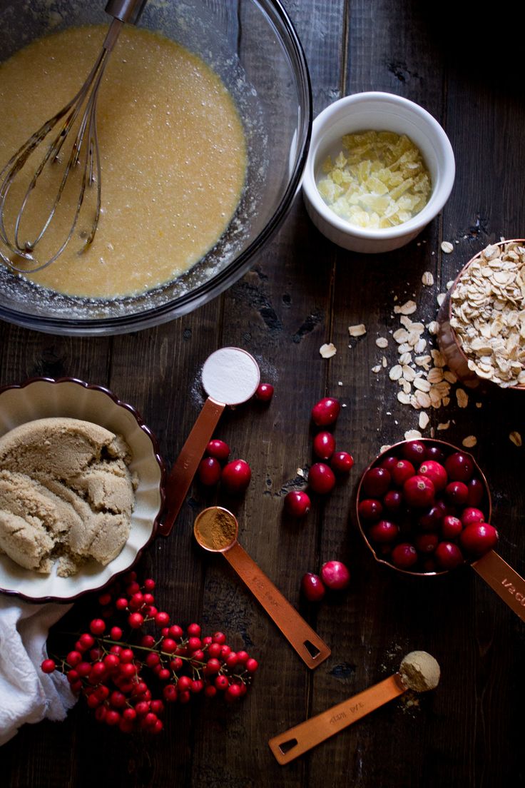 ingredients to make cranberry ice cream laid out on a wooden table with bowls and spoons