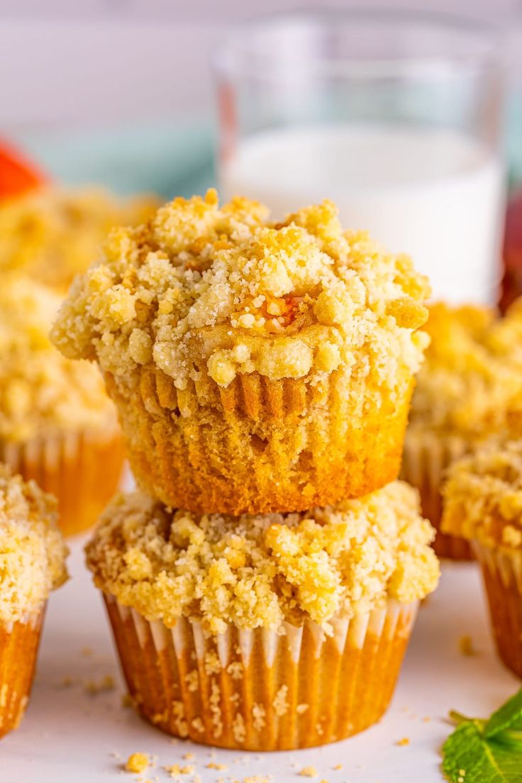 several muffins are stacked on top of each other with fruit in the background