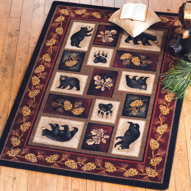 a rug with bears on it and pine cones in the corner next to an open book