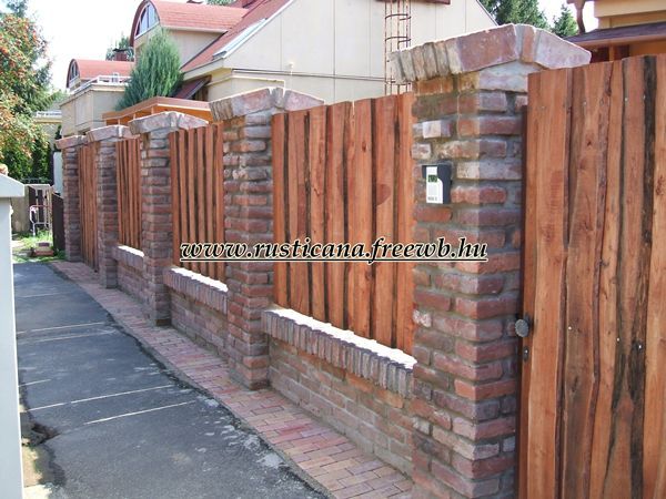 a brick fence is next to a house