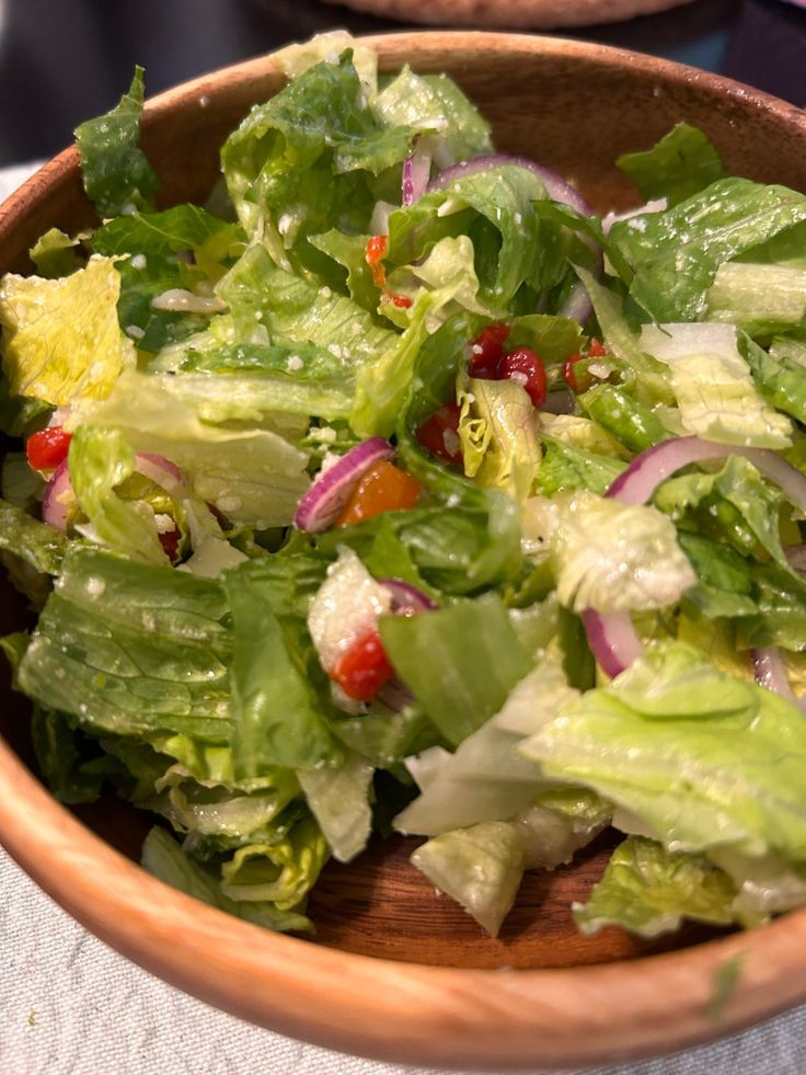 a salad with lettuce and tomatoes in a wooden bowl