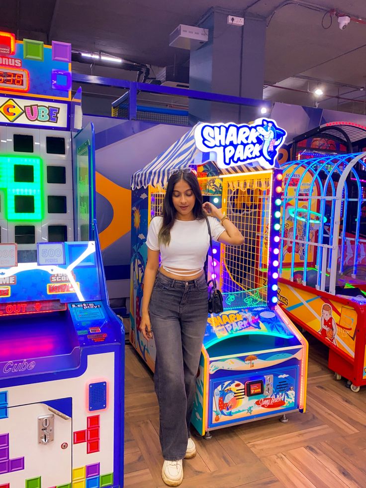 a woman is standing in front of some arcade machines and playing games on the floor