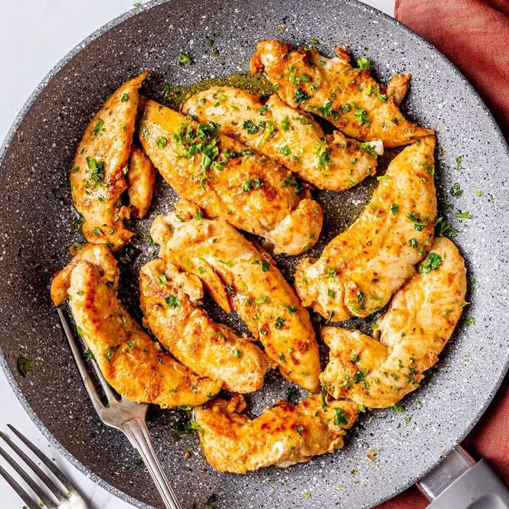 chicken wings in a pan with a fork and knife