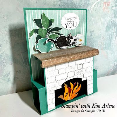 a card with a cat sitting on top of a fire place in front of a wall