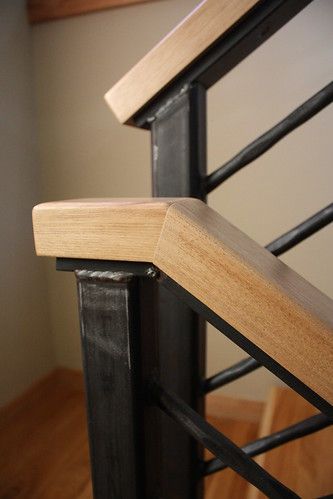 a wooden stair rail with metal handrails