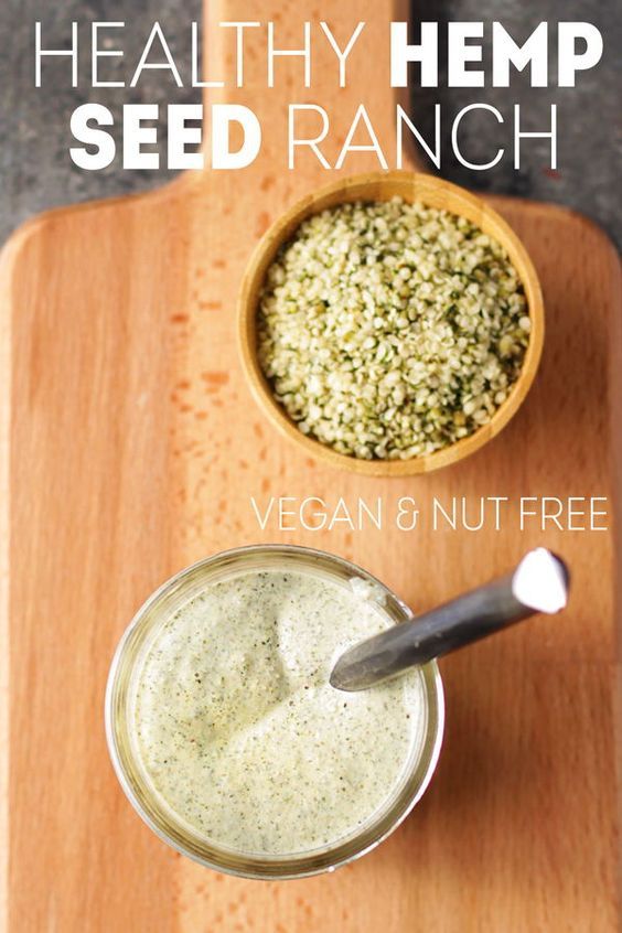 healthy hemp seed ranch in a small bowl next to a spoon on a cutting board