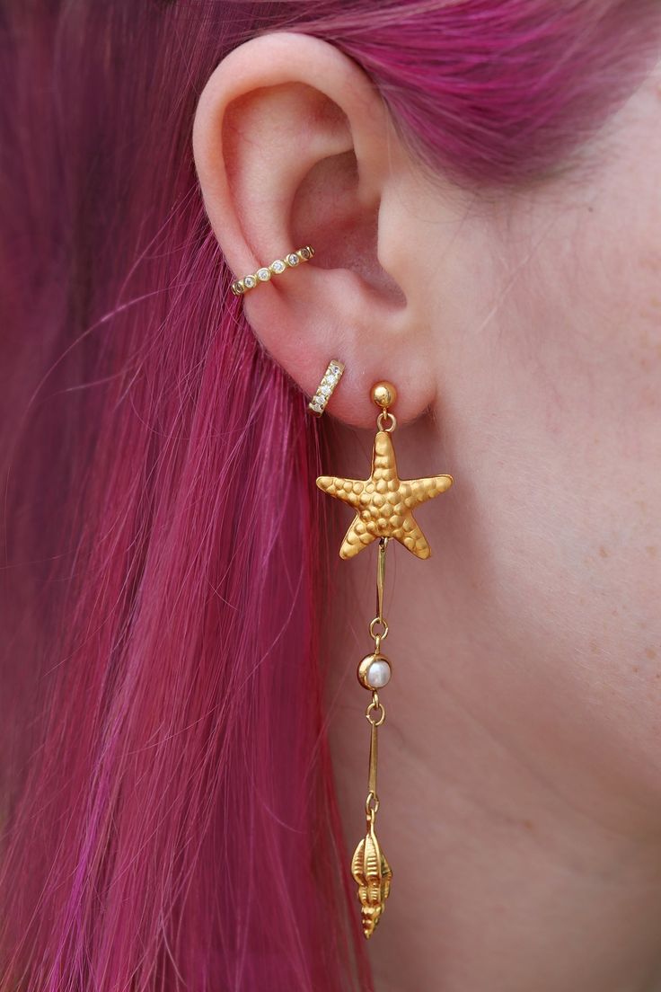 Channel your inner mermaid by rocking my under the sea drops! Featuring handmade starfish, spiral shells and pearls inspired by the ocean floor. The starfish are handmade by an indigenous Thai hill tribe from sterling silver, then plated in 14k gold in Rhode Island. They are very lightweight but perfect for a night out dancing as they have immediate movement on their own! These lovely long earrings pop out when you walk and show up even with long hair worn down when other earrings tend to disappear in photos. Manmade pearls Sterling silver starfish & shells handmade and 14k gold plated 14k gold-fill nickel-free posts with strong rubber backs which are more secure than metal backs 3.25" long Gold Starfish Jewelry With Pearl Charm, Ocean-inspired Starfish Dangle Jewelry, Bohemian Gold Starfish Jewelry, Matric Dance Dress, Shells And Pearls, Dance Dress Ideas, Spiral Shell, Matric Dance, Ocean Floor