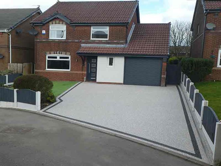 a house with a driveway and gate in front of it