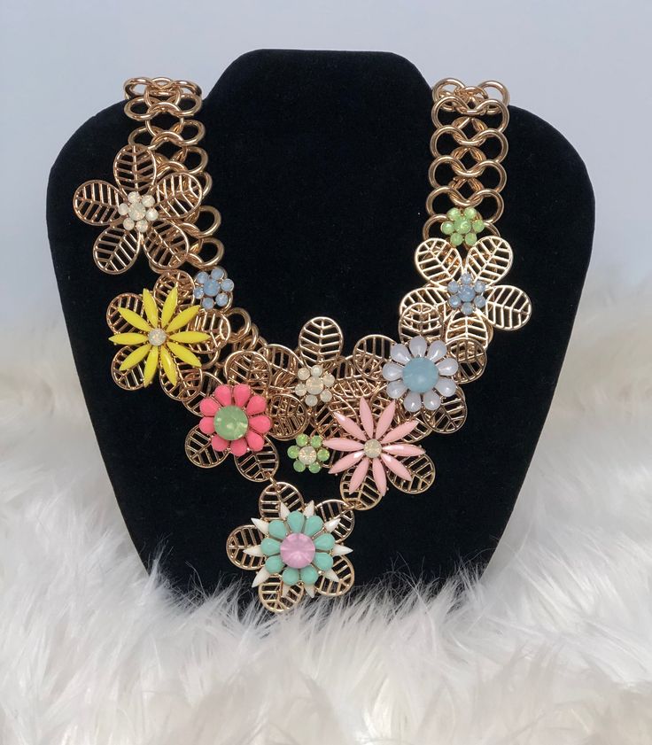 Statement Necklace with flower accents in various colors. Spring Chic Jewelry With Flower Decoration, Chic Spring Jewelry With Flower Decoration, Spring Flower Jewelry With 3d Flowers, Spring Flower Shaped Jewelry With 3d Flowers, Chic Spring Jewelry With Flower Charm, Spring Party Flower Necklace With Charm, Spring Party Flower Charm Necklace, Spring Jewelry With 3d Flowers, Handmade Flower-shaped Chic Jewelry