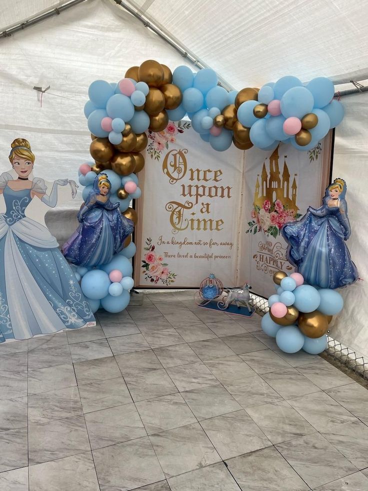 balloon arches with princesses and balloons on the floor in front of a sign that says once upon a one