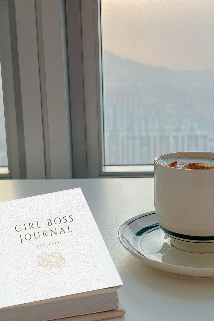 a cup of coffee sitting on top of a saucer next to a book