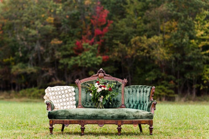 a green couch sitting on top of a lush green field