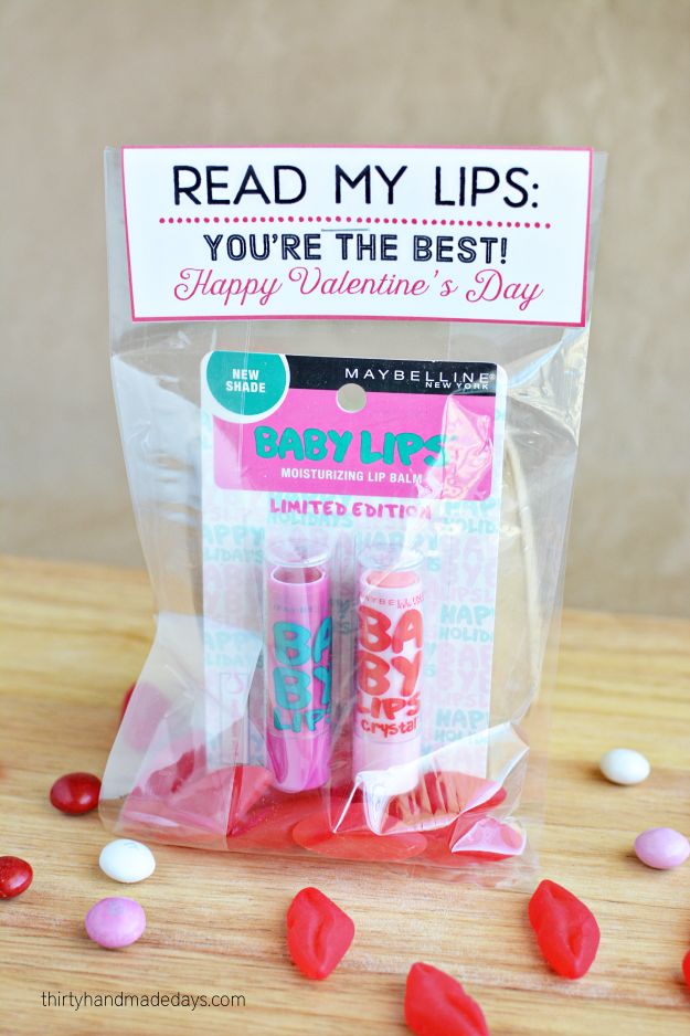 two lip bales in a plastic bag with candy on the table next to it