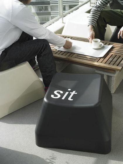 two people sitting at a table with a sign on it that says sit next to each other