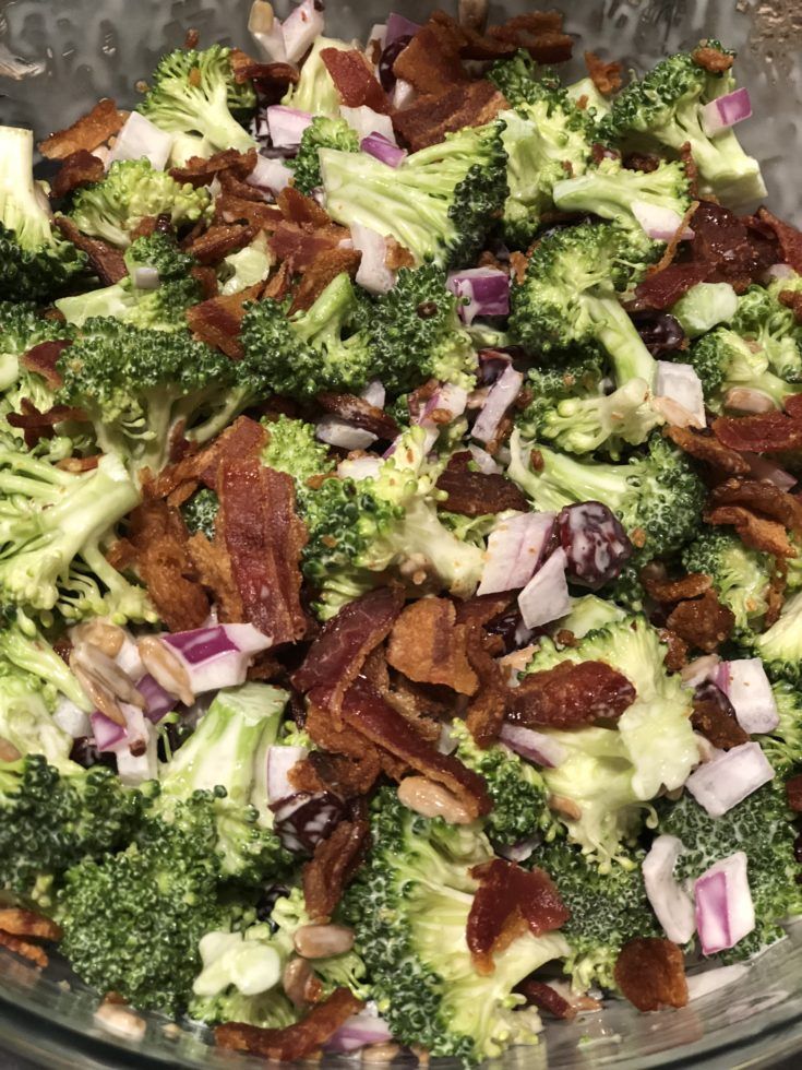 a glass bowl filled with broccoli and bacon