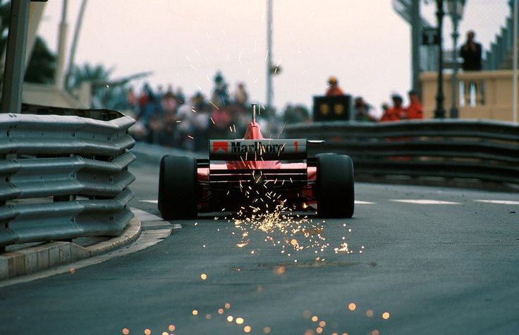 a red race car is driving down the track