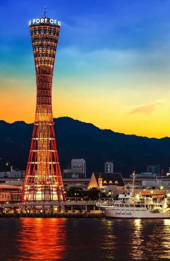 a very tall tower sitting in the middle of a lake next to a city at night