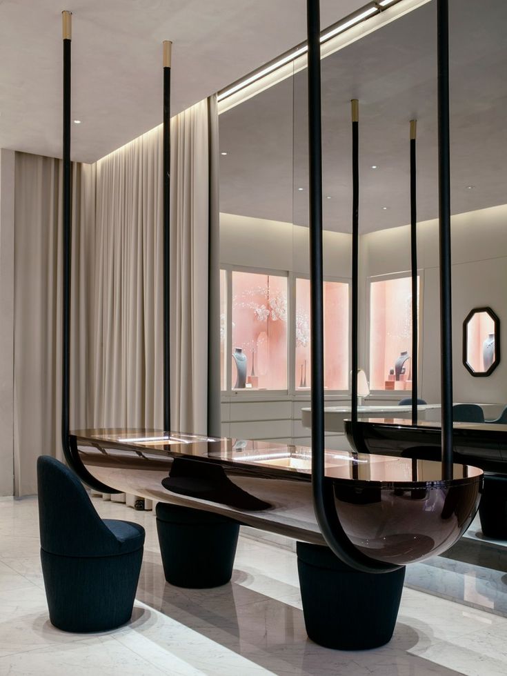 an elegant dining room with black chairs and tables in the center, along with large mirrors on the wall