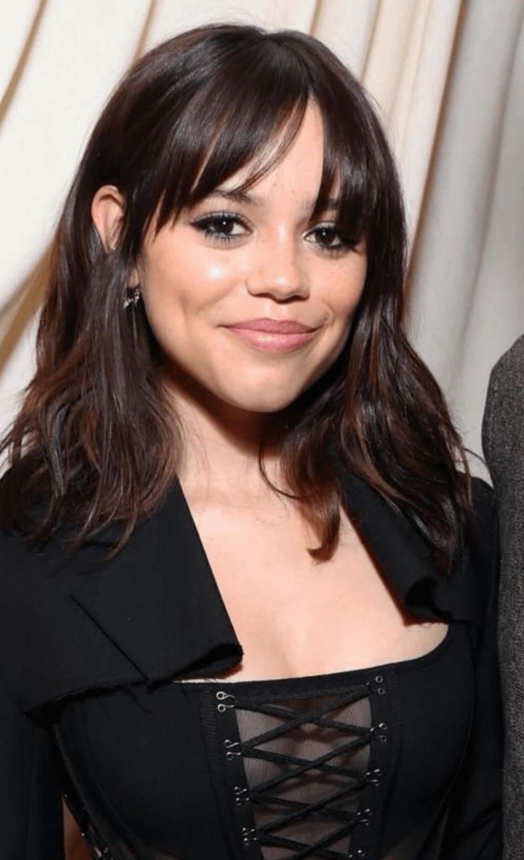 a woman in a black dress posing for the camera