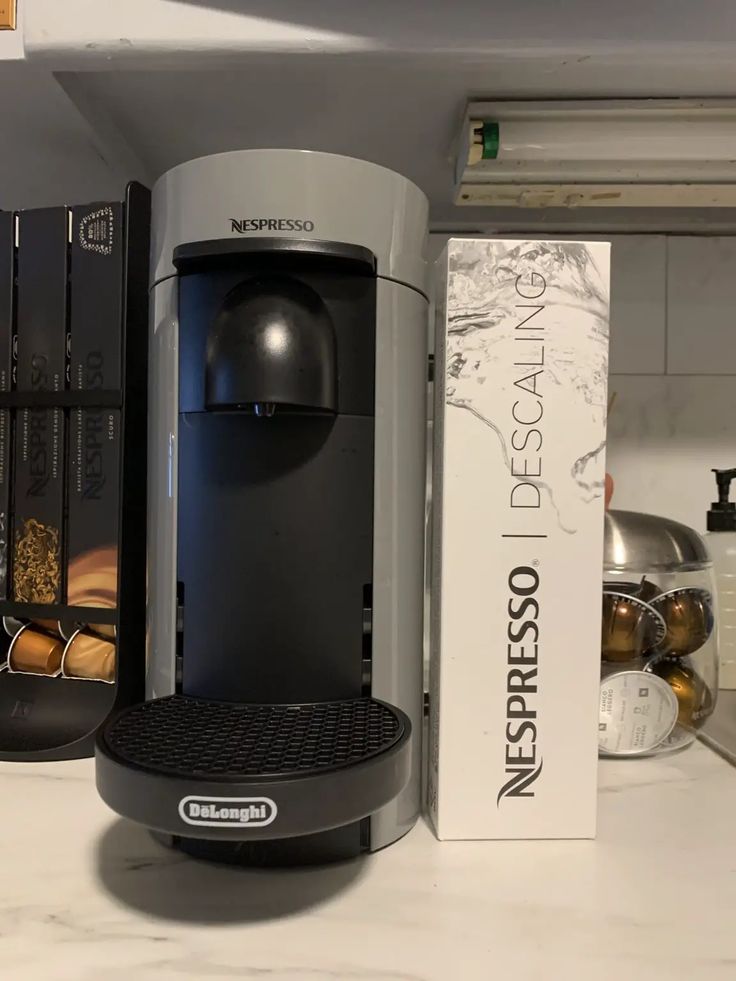 an espresso machine sitting on top of a counter next to a box of donuts