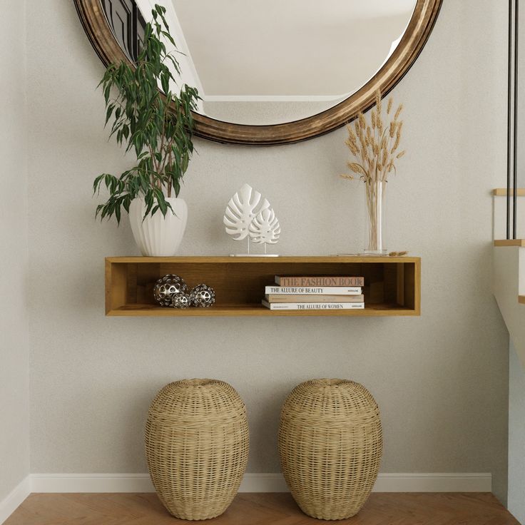 two wicker stools sit in front of a round mirror on the wall next to a shelf with books