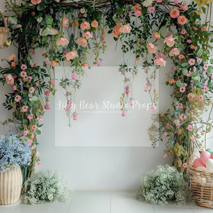 an arrangement of flowers and greenery in front of a white wall