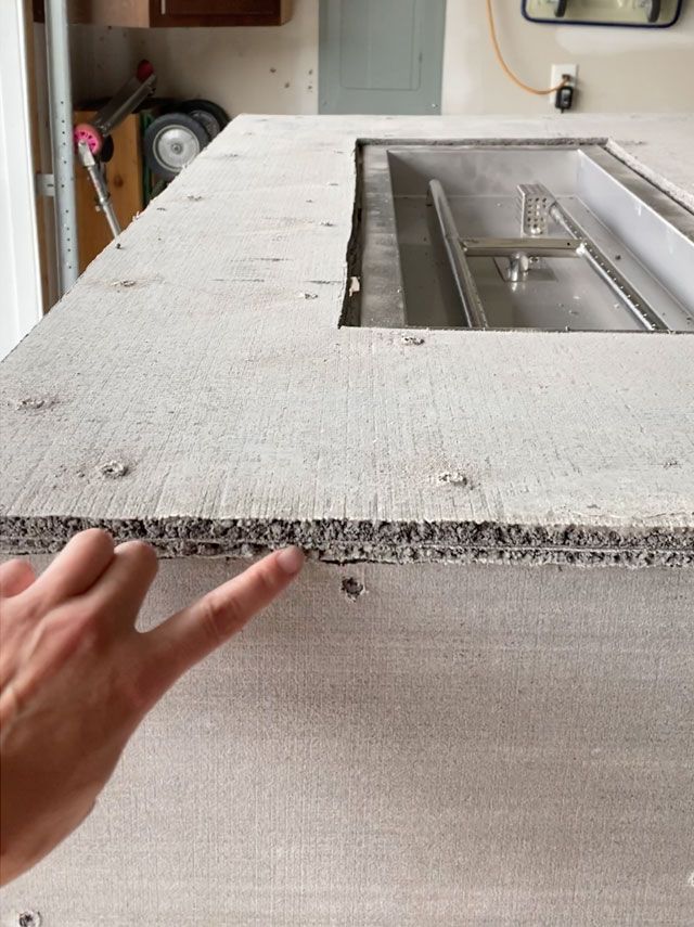 a hand pointing at a sink in a kitchen