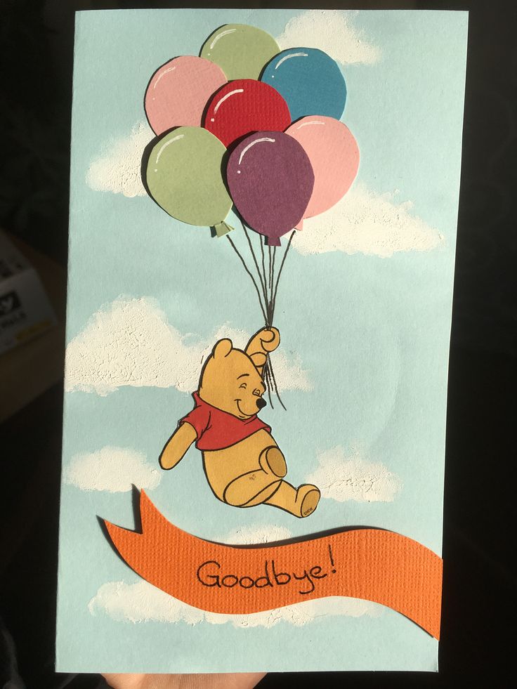 a hand holding up a card with winnie the pooh on it and some balloons