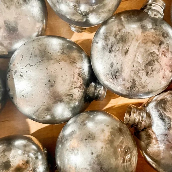 many silver ornaments are sitting on a wooden table