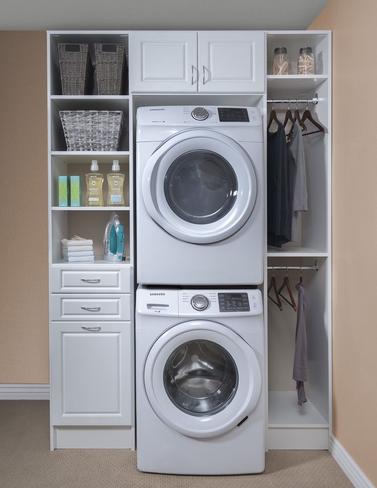 a washer and dryer in a small room with shelves on the wall behind them