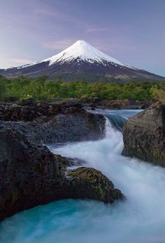 there is a mountain in the background with water flowing through it