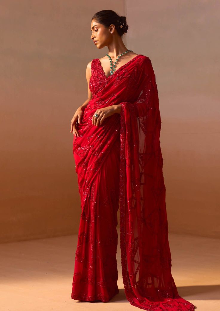 Embrace sophistication with this blood-red georgette sari featuring a tonal geometric jaal embellished with sequins, beads, and cutdana work. Paired with a stylish sleeveless blouse adorned with a matching jaal, this ensemble exudes elegance and charm. Designer Red Saree, Red Saree For Farewell, Red Saree Party Wear, Red Saree Look, Shimmer Saree, Gorgeous Saree, Saree Styling, Cutdana Work, Red Sari