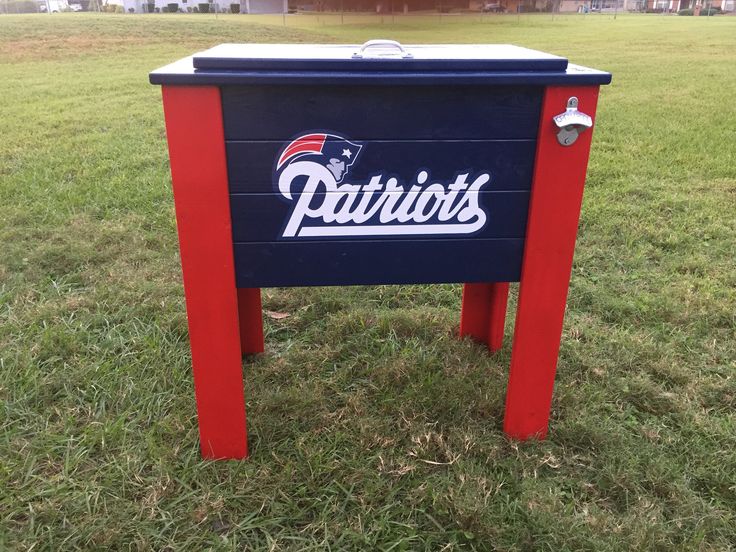 a blue and red box with the word detroit on it in grass next to a field