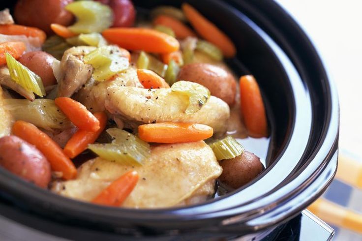 a crock pot filled with chicken, carrots and celery