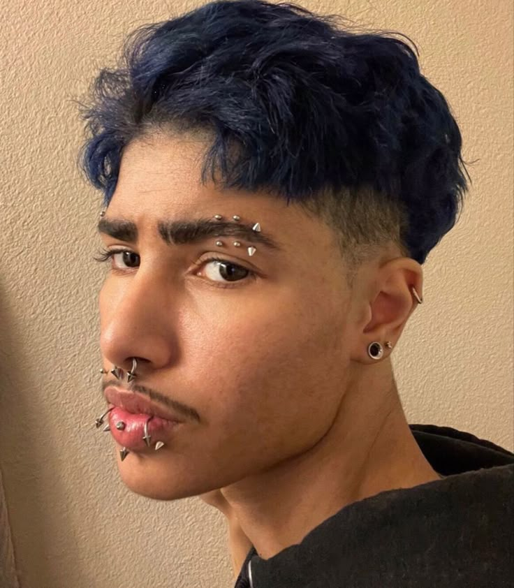 a man with blue hair and piercings on his nose