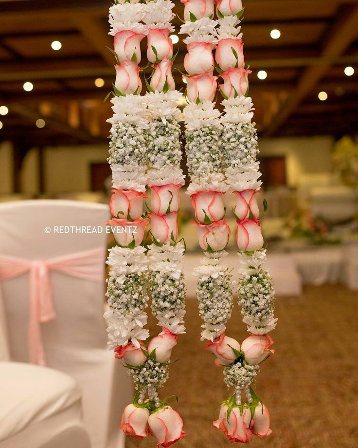 wedding decorations hanging from the ceiling at a banquet hall with pink and white flowers on it