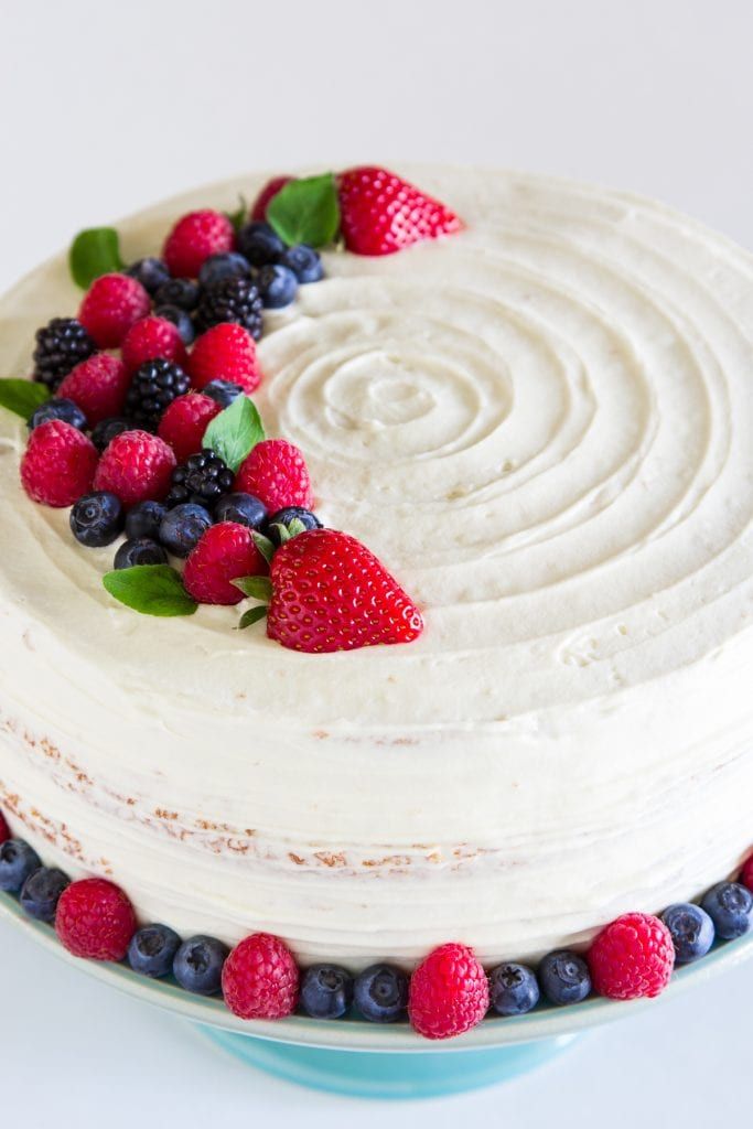 a white cake with berries and blueberries on top