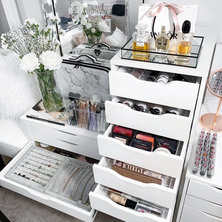 a white dresser with drawers filled with makeup and personal care items