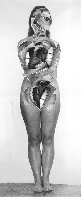 an old photo of a woman with her body wrapped in snake's teeth, standing on the floor