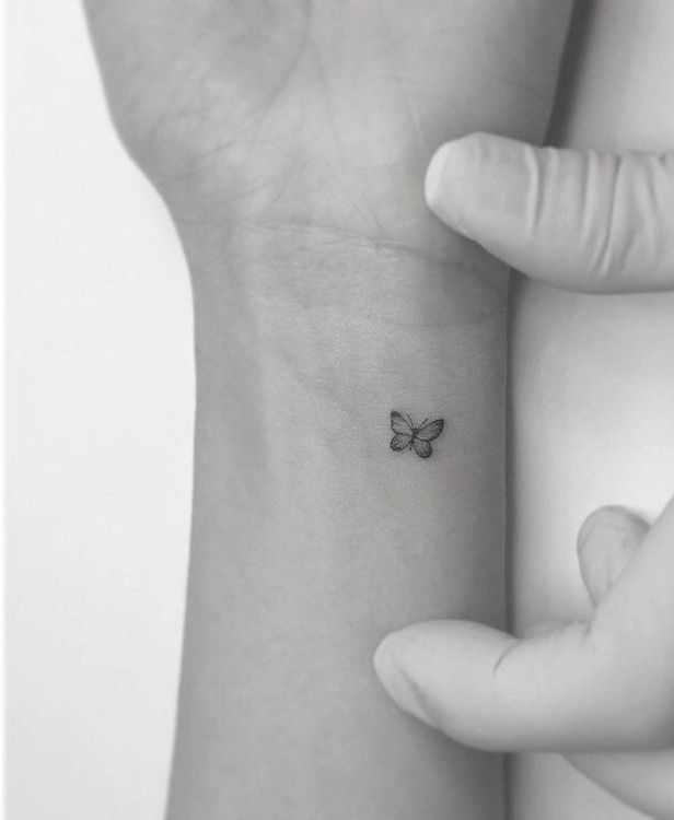 a small butterfly tattoo on the wrist