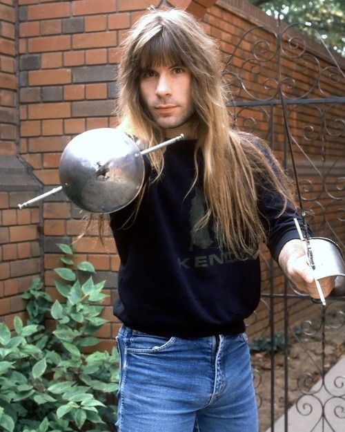 a man with long hair holding a pot and ladle