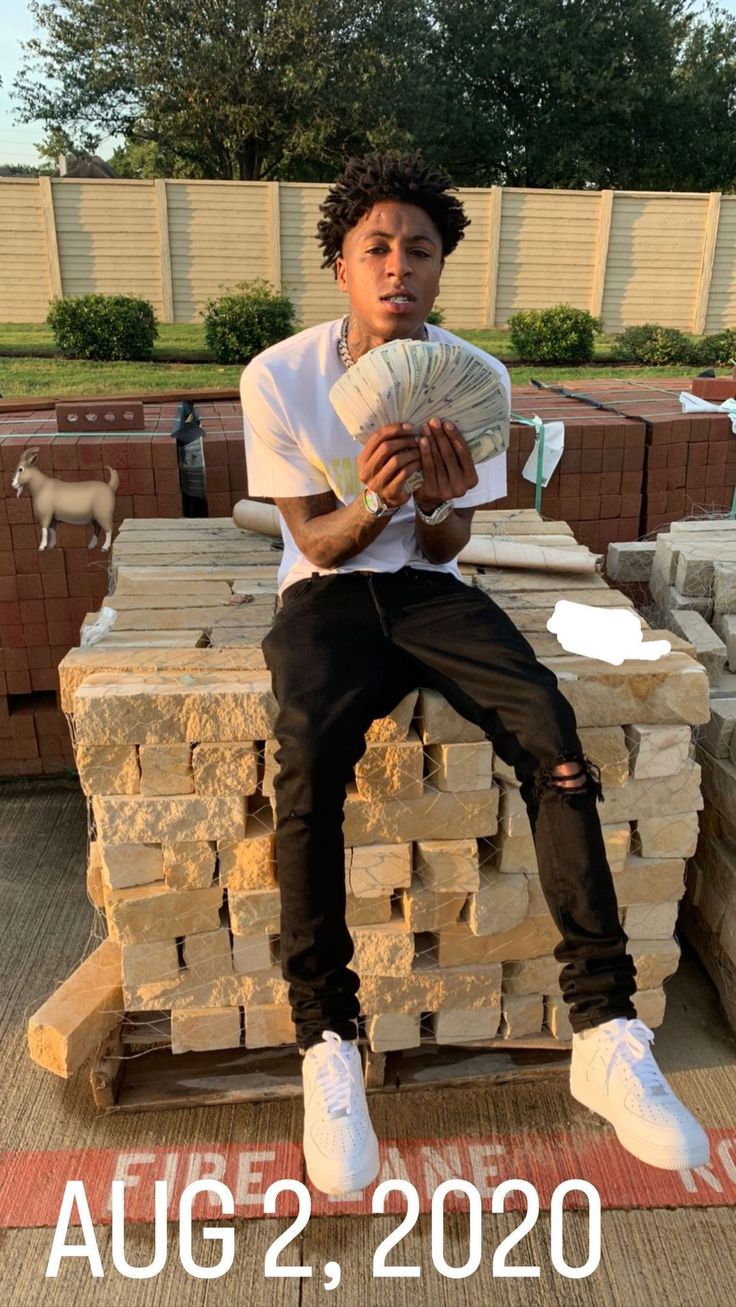 a young man sitting on top of stacks of bricks