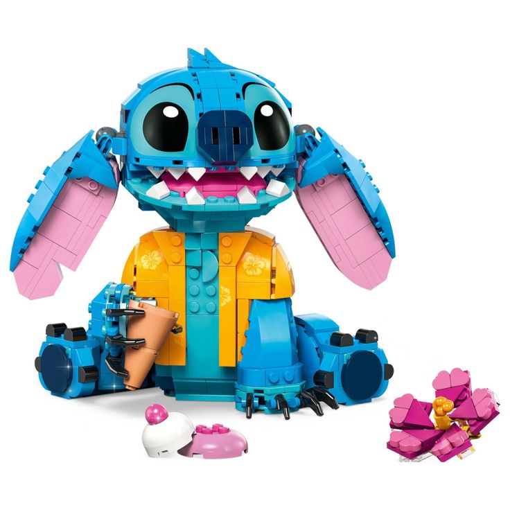 a blue and yellow toy with large teeth on it's face, sitting next to other toys