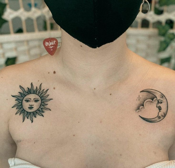 a woman wearing a black face mask with sun and moon tattoos on her chest