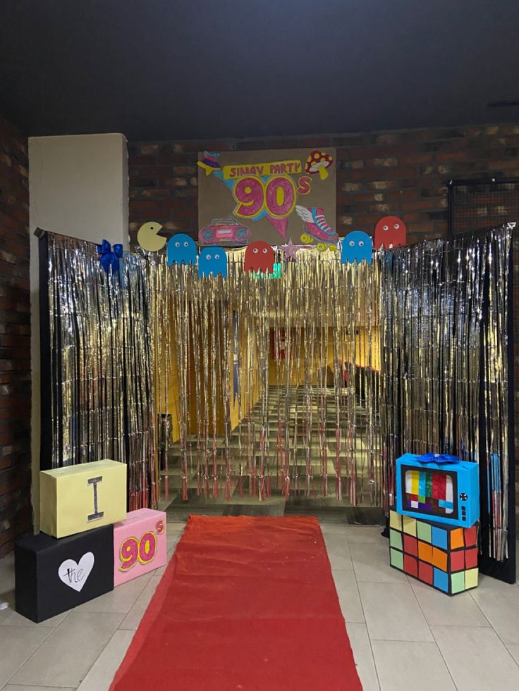 an entrance to a party with balloons and streamers on the door, red carpet